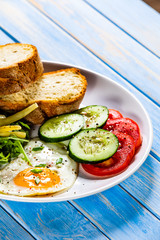 Breakfast - fried egg, toasts and vegetable salad