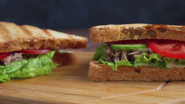sandwiches with tuna lettuce cucumber on cutting board panning shot
