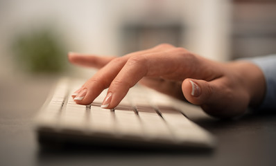 Hand typing on keyboard with office concept
