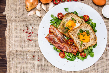 Breakfast - toasted bread with fried egg, bacon and vegetables