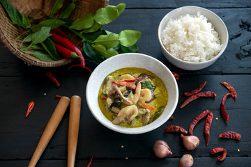 Green curry with  shrimp and meat on dark wood floor