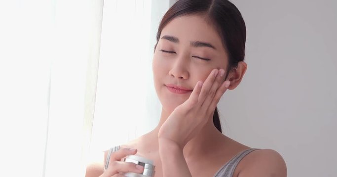 Beautiful asian woman looking to camera and touch her face.