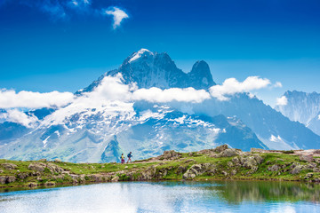 Naklejka na ściany i meble Fantastic landscape with with tourists and reflection of mountains in the lake on the background of Mont Blanc, French Alps, Europe. (Harmony, tourism, meditation - concept)