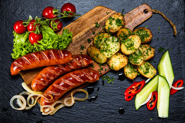 Grilled sausages and vegetables on cutting board