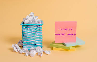Conceptual hand writing showing Don T Wait For Opportunity Create It. Concept meaning work hard on yourself and begin from this moment crumpled paper and stationary paper placed in the trash can