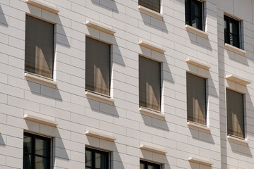 Fototapeta premium windows building facade with closed shutters / sun blinds