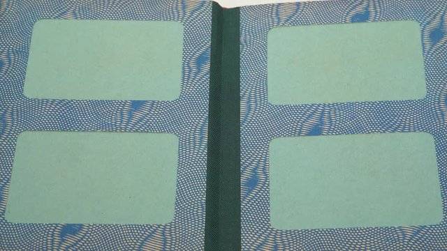 Woman turning pages of old vintage paper album with empty green space for pictures. Closeup point of view video footage in 4k.