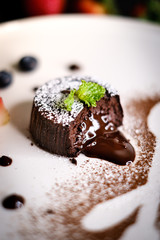 Molten chocolate lava cake with berries on white plate.