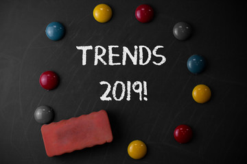 Word writing text Trends 2019. Business photo showcasing general direction in which something is developing or changing Round Flat shape stones with one eraser stick to old chalk black board