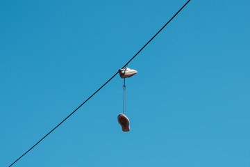 one pair of shoes hanging from a wire