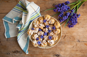 Homemade biscuit with violet hyacinth, white flower and yellow taraxacum on the wooden table