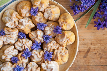 Homemade biscuit with violet hyacinth, white flower and yellow taraxacum on the wooden table