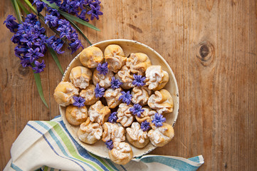 Homemade biscuit with violet hyacinth, white flower and yellow taraxacum on the wooden table