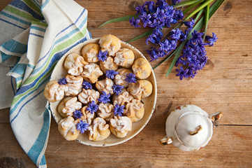Homemade biscuit with violet hyacinth, white flower and yellow taraxacum on the wooden table