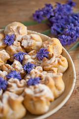 Homemade biscuit with violet hyacinth, white flower and yellow taraxacum on the wooden table