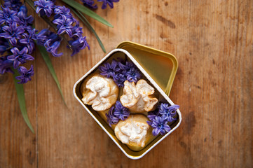Homemade biscuit with violet hyacinth, white flower and yellow taraxacum on the wooden table