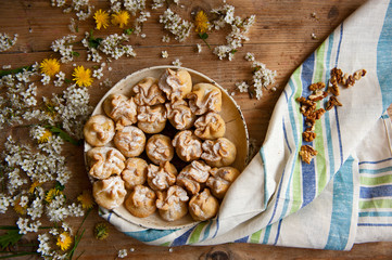 Homemade biscuit with violet hyacinth, white flower and yellow taraxacum on the wooden table