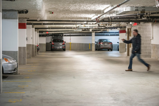 Man Rushing To Car In Parking Garage