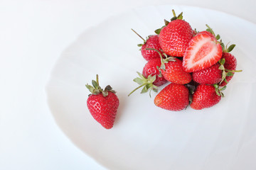 Close-up shot of fresh strawberries on a white plate. Isolated on white background.