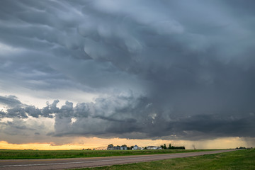 Dramatic sky as a severe thunderstorm passes a farm in the Nebraska panhandle. Mammatus clouds are...