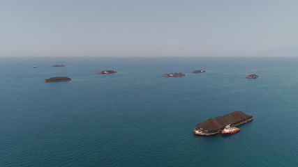 aerial view barges full coal anchored at sea near coal fired power station waiting be transported. coal barges and tugboats java, paiton indonesia