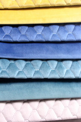 Colorful patterns of upholstery fabric. Close-up of samples of furniture fabric. Multi-colored soft fabric with stitch effect. Furniture industry. Background texture.