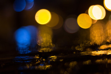 Blurred city lights with rain on the paving stone