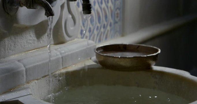 detail view of washbasin and two tap with water in old bathhouse