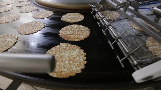 Rawpancakes on hot conveyor belt