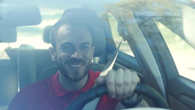 Portrait smiling young handsome happy man use phone in the car look at camera driver mobile automobile cell drive hand smartphone auto business communication traffic businessman telephone