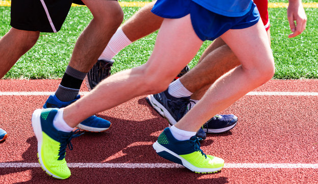 Legs of a group of runners on the track ready to start a run