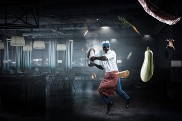 Fototapeta premium Black man wearing an apron and cooking in action. Mixed media