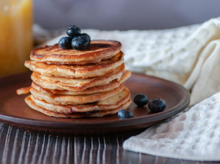 Pancakes with blueberry and honey. On a wooden table with a white towel