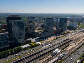 Aerial of modern office buildings on the Amsterdam Zuidas business district connected by highway and train station