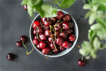 cherry berries in a plate, mint branches, top view,
