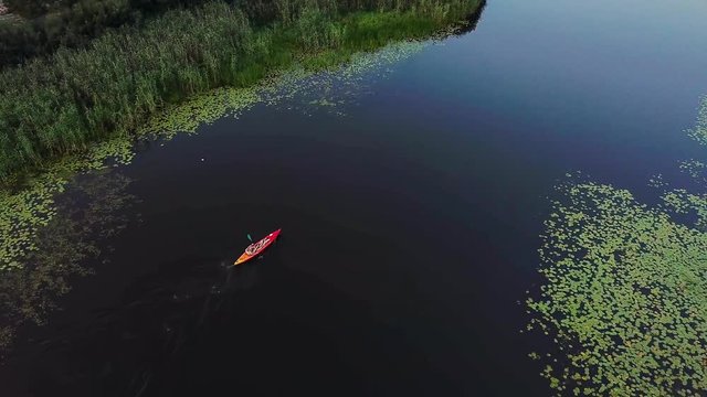 aerial view of red kayak on the lake, Aerial view of a tourist boat, fly above the red kayak at the river,top view of mans Traveling by canoe