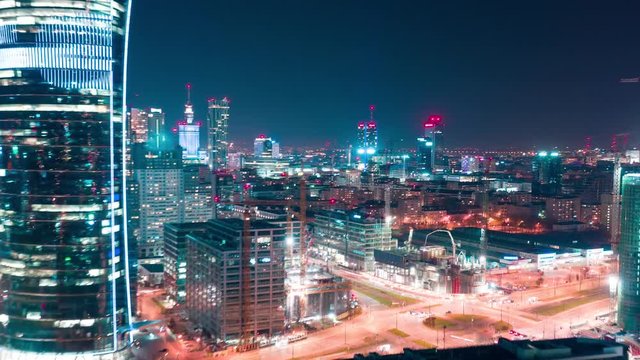 Aerial hyperlapse of Warsaw business center at night: skyscrapers and Palace of Science and Culture