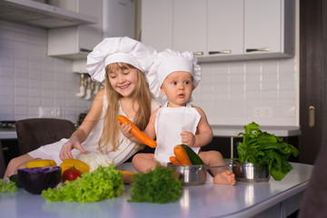 little girl and boy, white chef hat, vegetables