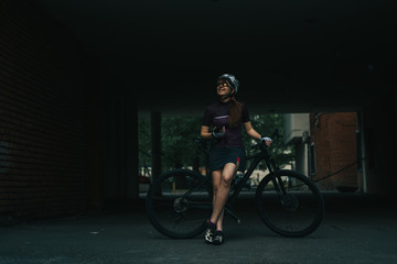 Woman posing next to her bicycle.