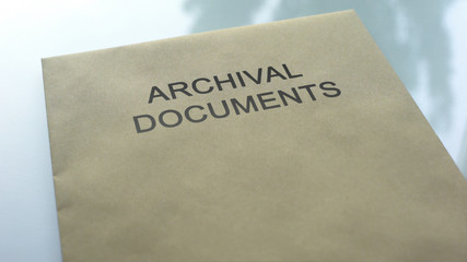 Archival document, folder with important documents lying on table, close up