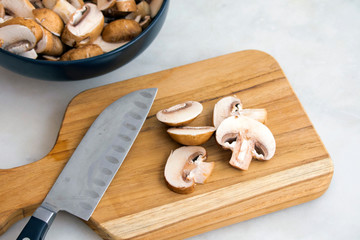 Slicing Cremini Mushrooms on a Wood Cutting Board