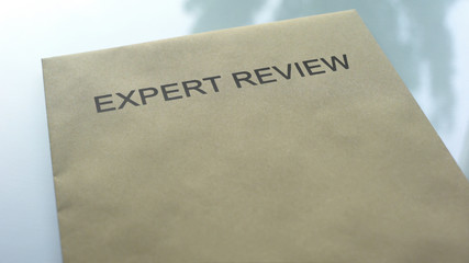 Expert review, folder with important documents lying on table, investigation