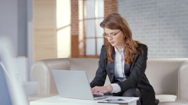 Pretty businesswoman working on laptop in expensive office, responsible officer