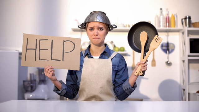 Inexperienced housewife asking for help in cooking, wearing pot on head, joke