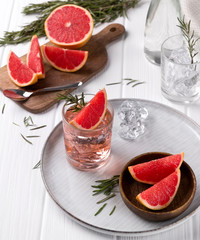 Fototapeta na wymiar Grapefruit cocktail with rosemary on white wooden table