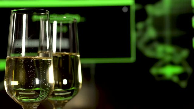 Two glasses with sparkling champagne over haker programme background.