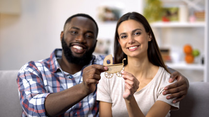 Cheerful mixed-race couple holding paper baby carriage, child expectation, dream