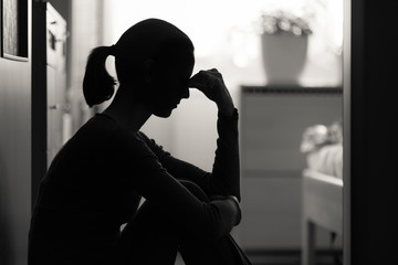 Female sitting alone at home stressed with problems and worries. 