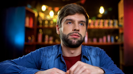 Caucasian male unhappy with favorite team missing goal, watching game in bar