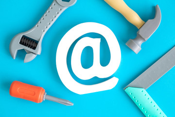Plastic carpentry tools and email symbol abstract isolated on blue.